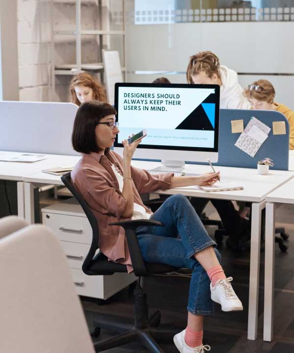 A woman talking on phone with client in office.